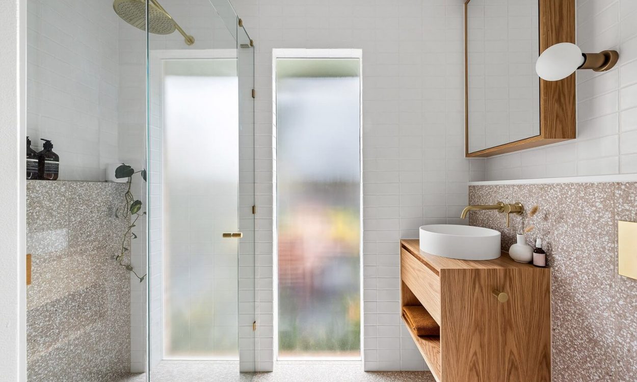 Pink Terrazzo Tiles paired with White Brick Tiles Custom Small Vanity Brushed Brass Fitings Shower Seat Fluted Glass Window